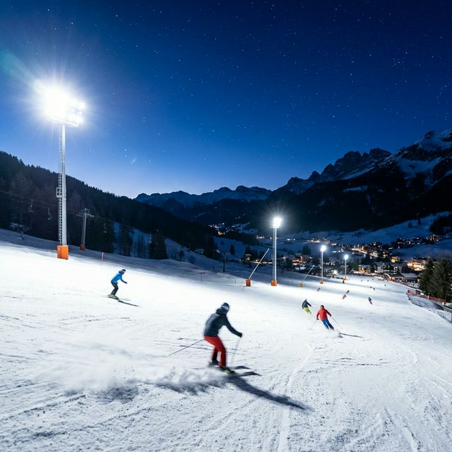 Pista da sci illuminata di notte con luci soffuse e neve